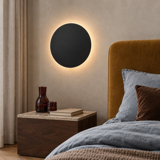Applique Borgen noire au-dessus d'une tête de lit ocre