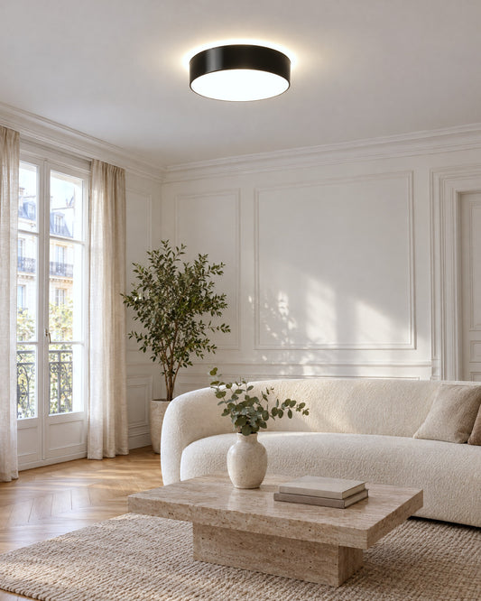 Plafonnier Arena noir rond allumé dans un salon parisien lumineux
