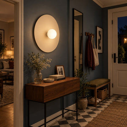 Applique Ake beige allumée dans une entrée au mur bleu