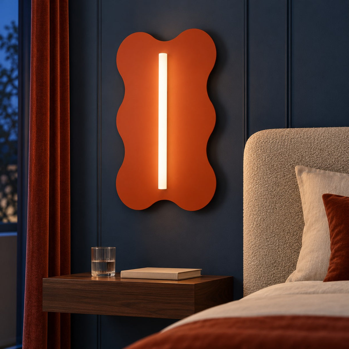 Applique Klover ocre rouge allumée dans une chambre bleu encre, vue rapprochée