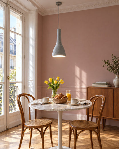 Suspension Empoli en béton au-dessus d'une table ronde en marbre dans une salle à manger parisienne