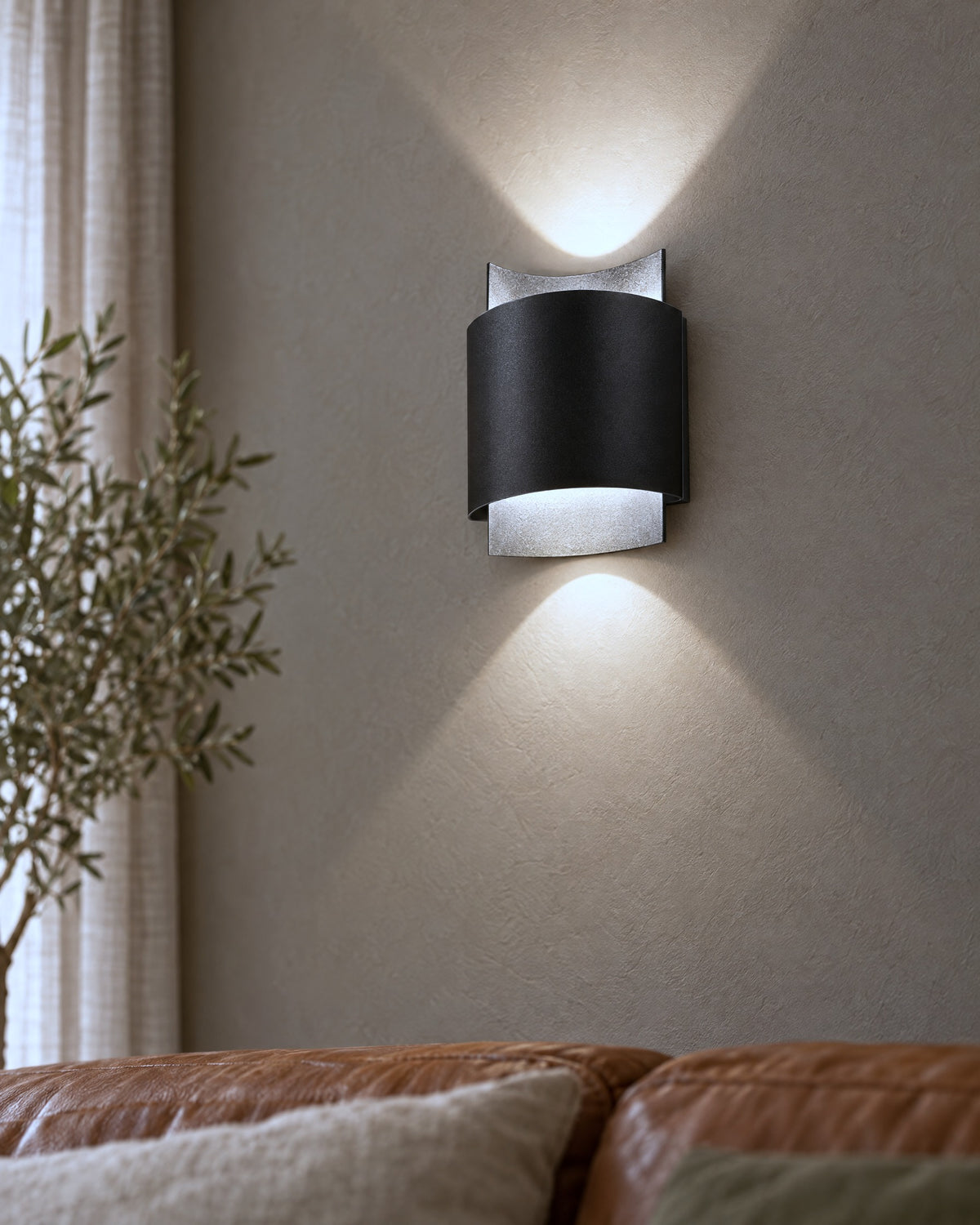 Détail de l'applique Impact noire et de ses faisceaux lumineux dans un salon