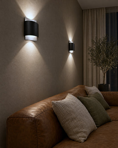 Applique Impact noire allumée le soir dans un salon