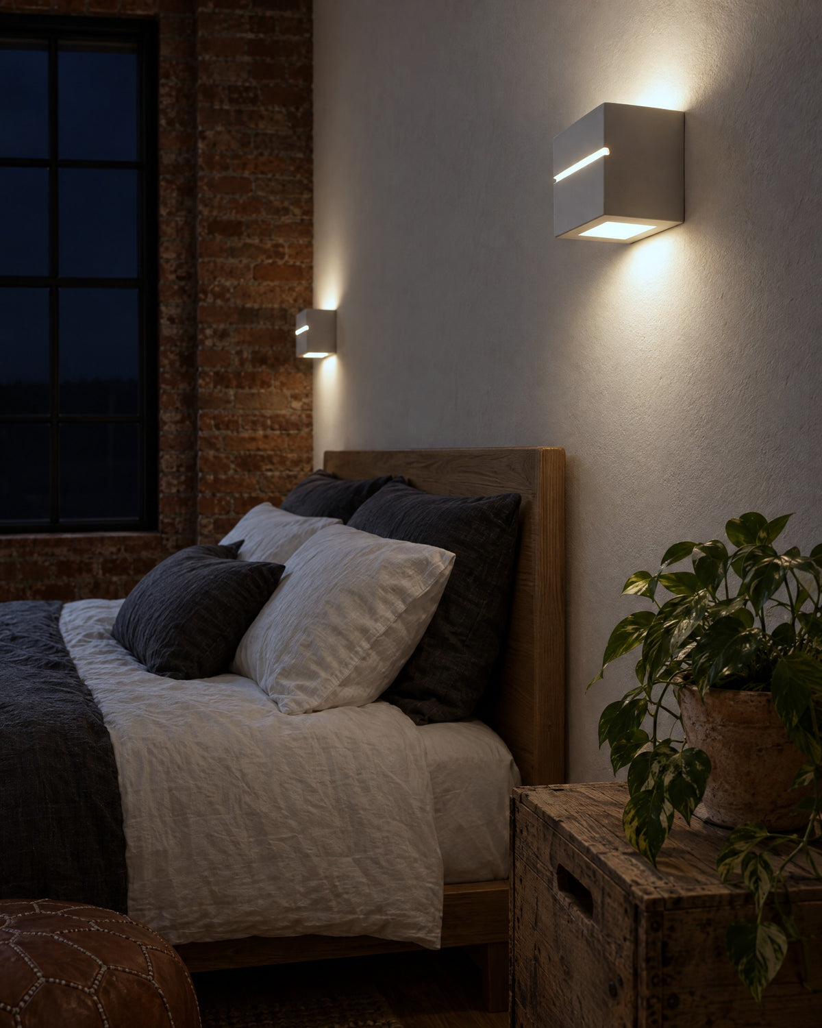 Applique Leo Line en céramique allumée le soir dans une chambre