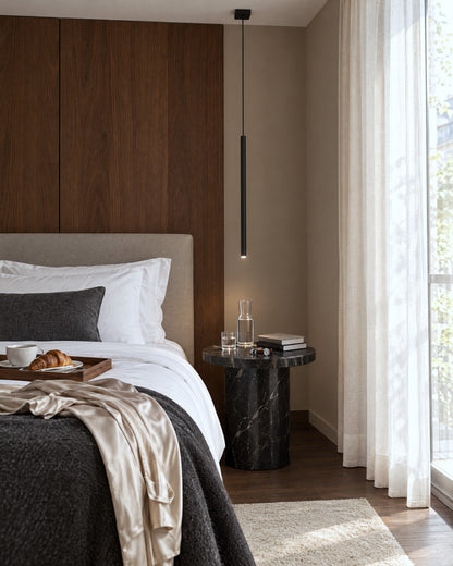 Suspension Pastelo noire très fine utilisée en lampe de chevet dans une chambre