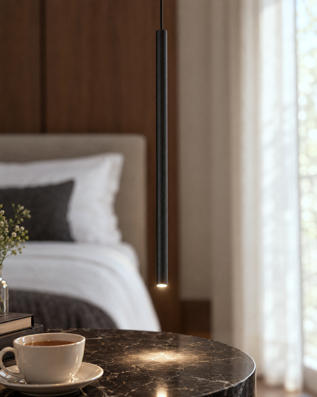 Détail du tube en métal noir de la suspension Pastelo dans une chambre