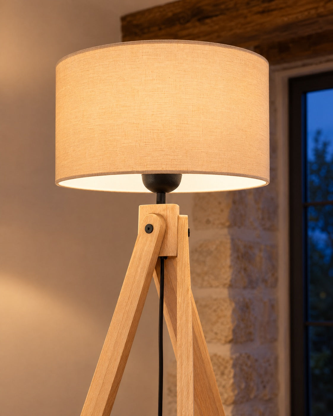Détail de l'abat-jour et du trépied en bois du lampadaire Natt dans un salon