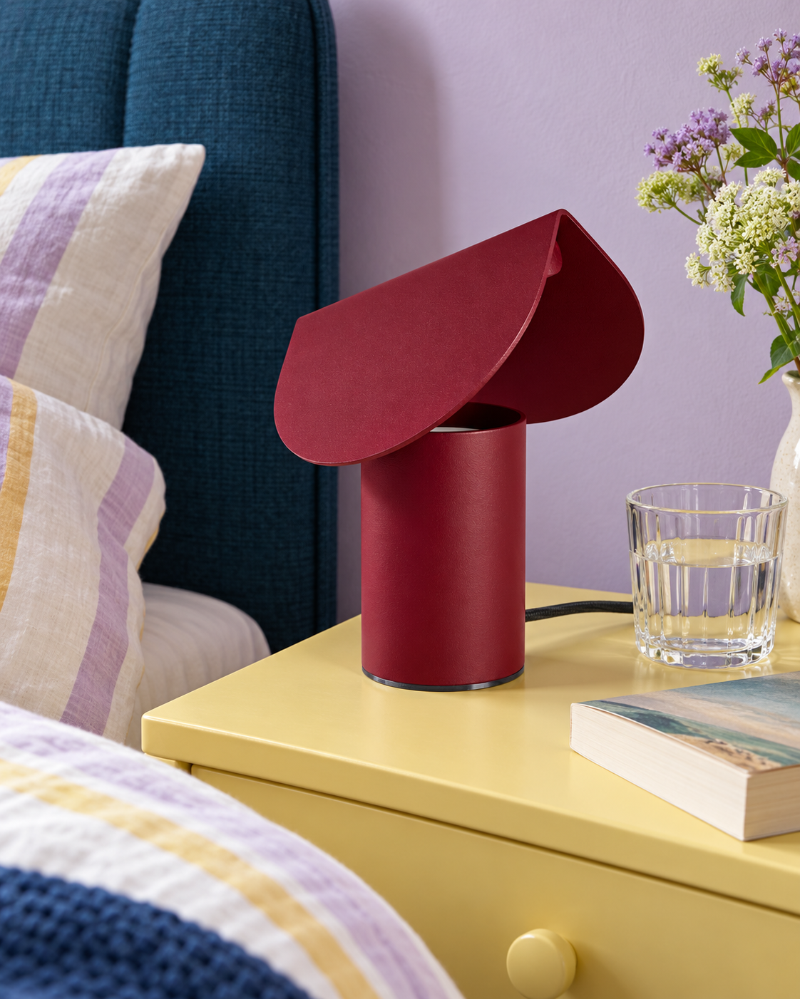 Lampe Biscuit bordeaux sur une table de chevet jaune