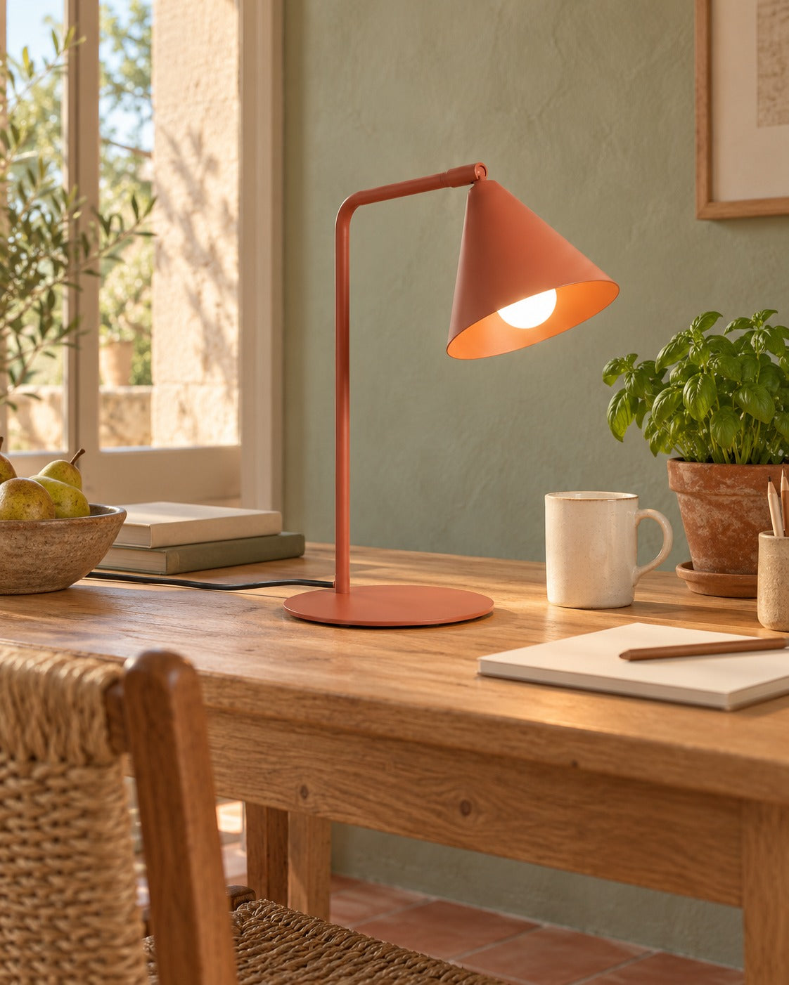 Lampe Nox ocre rouge sur une table de travail en bois dans un bureau
