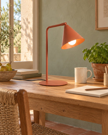 Lampe Nox ocre rouge sur une table de travail en bois dans un bureau