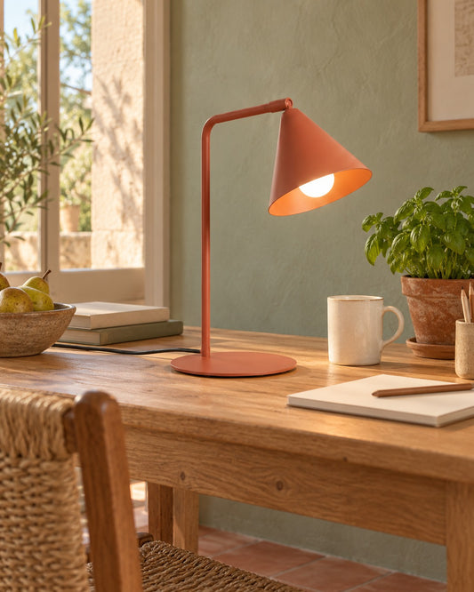 Lampe Nox ocre rouge sur une table de travail en bois dans un bureau