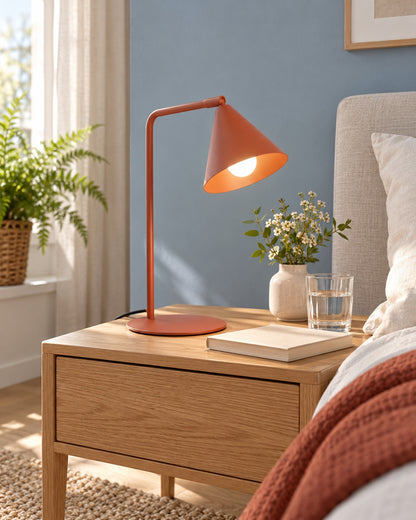 Lampe Nox ocre rouge sur une table de chevet dans une chambre